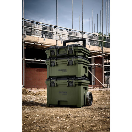 Stack of green storage boxes with 'Bunker' branding on a construction site background