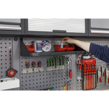 Person organizing tools in a Sealey garage storage unit.